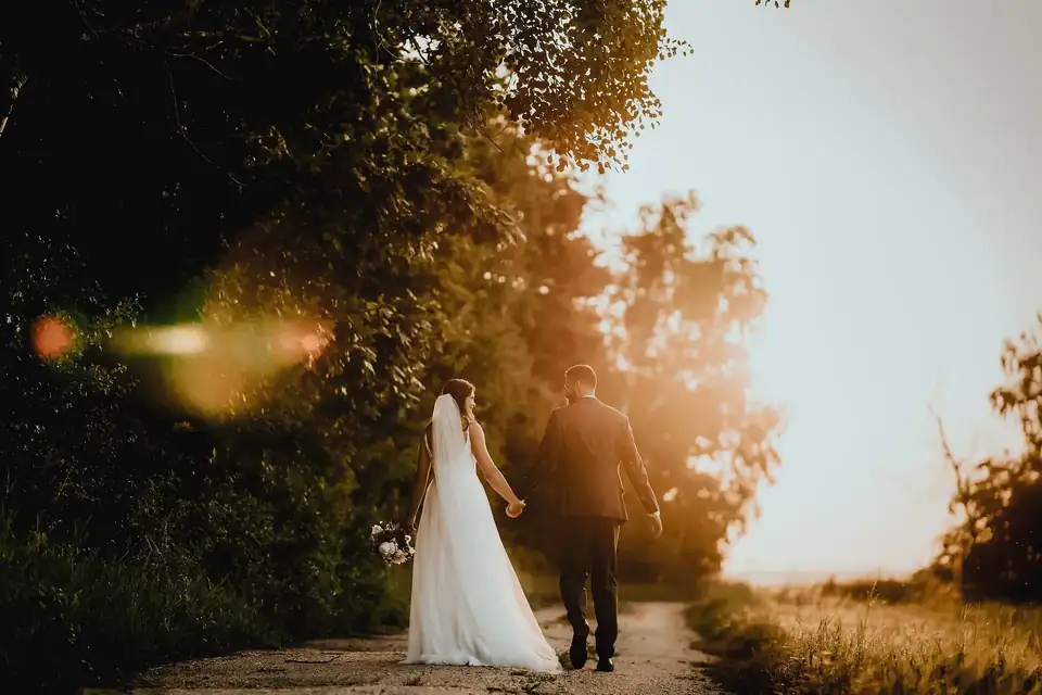 Couple walking hand in hand down a country lane at golden hour