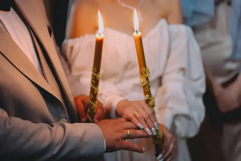 Couple holding lit candles together